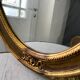 Grand miroir oval en stuc doré vintage