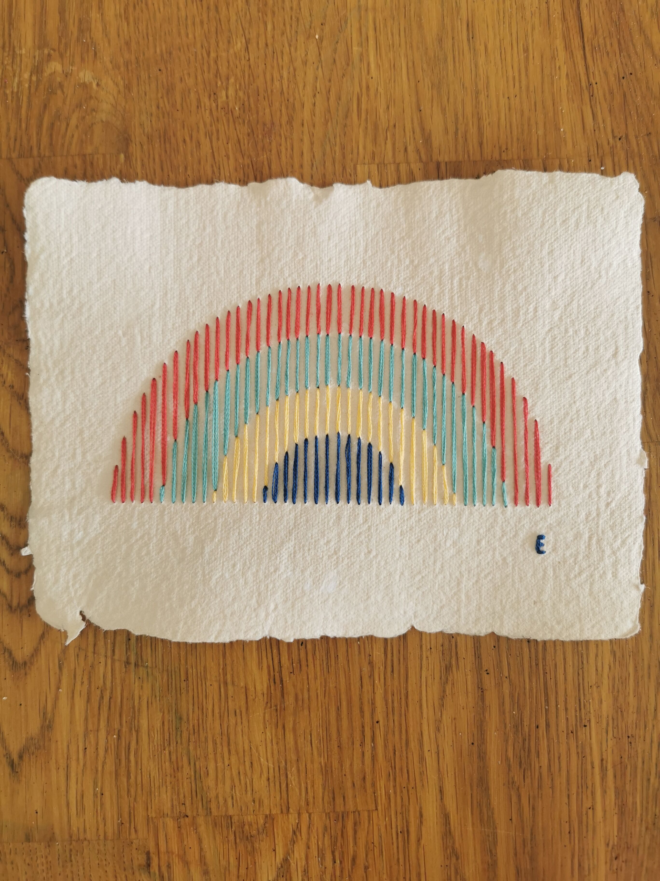 Rainbow embroidery on recycled paper