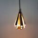 A teardrop-shaped pendant lamp made of copper, black metal, and prisms.