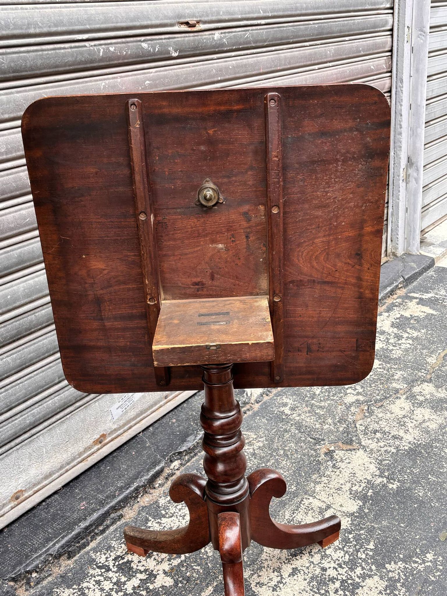 19th-century solid mahogany table with a tilting top and brass mechanism.