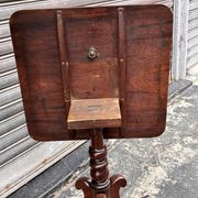 19th-century solid mahogany table with a tilting top and brass mechanism.