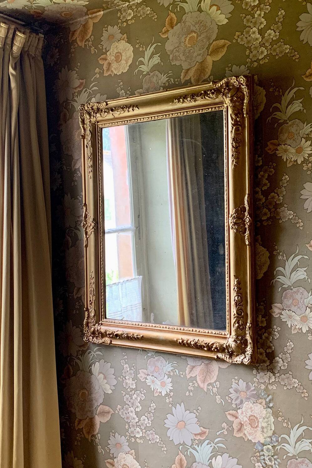 Miroir ancien en bois sculpté doré à décor de fleurs