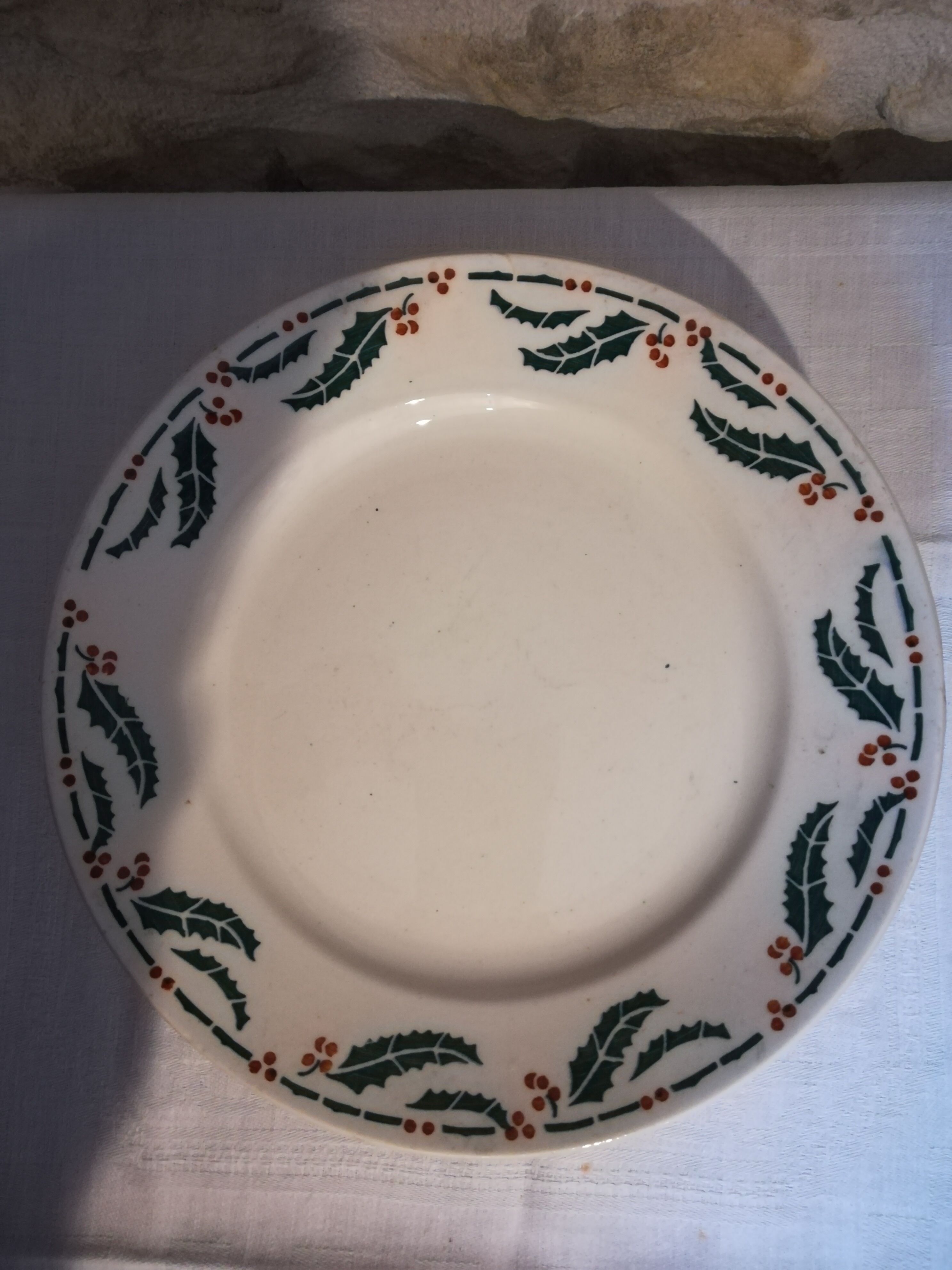 Six flat earthenware plates decorated with holly