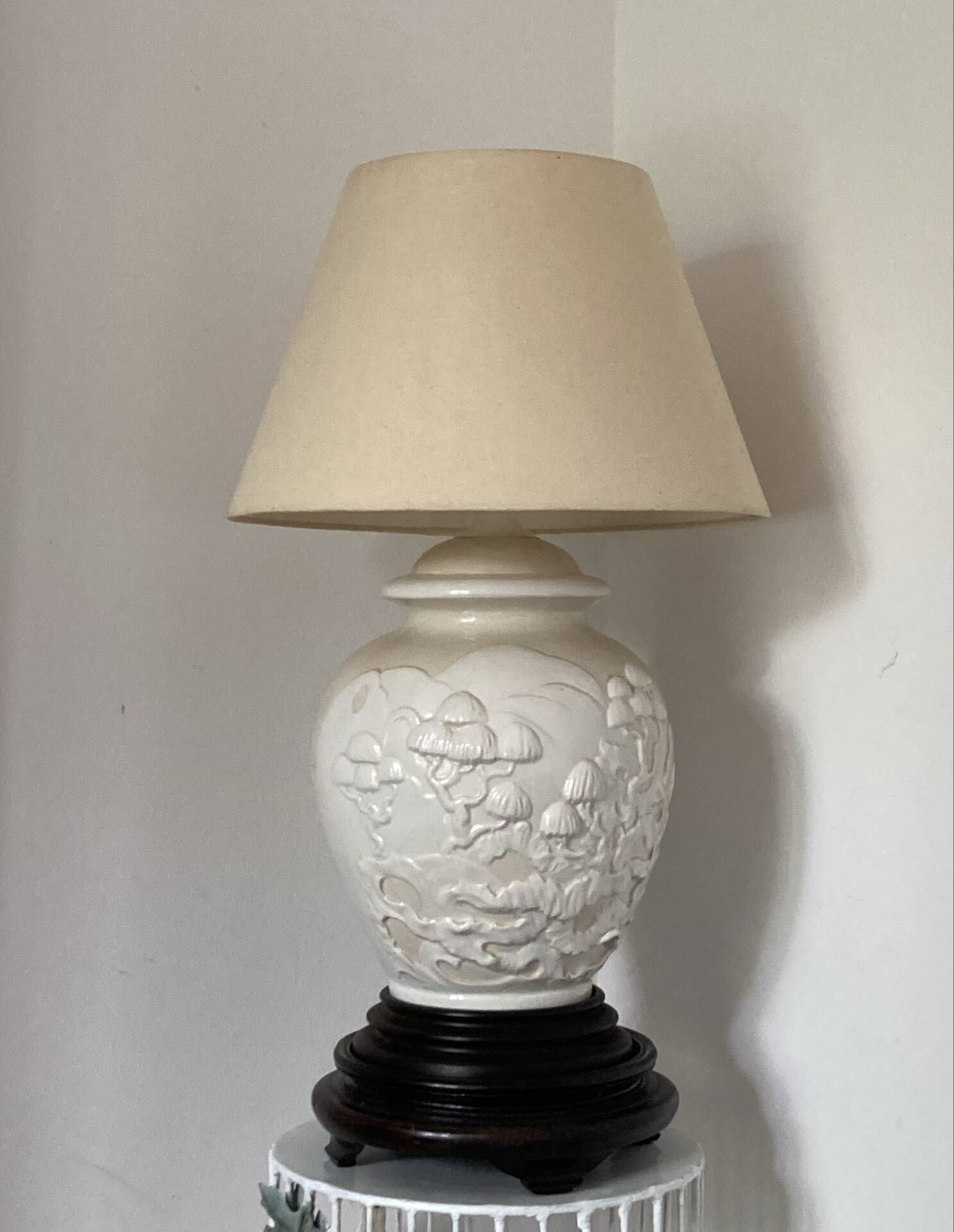 1980s ceramic table lamp with a wooden base and adjustable shade.