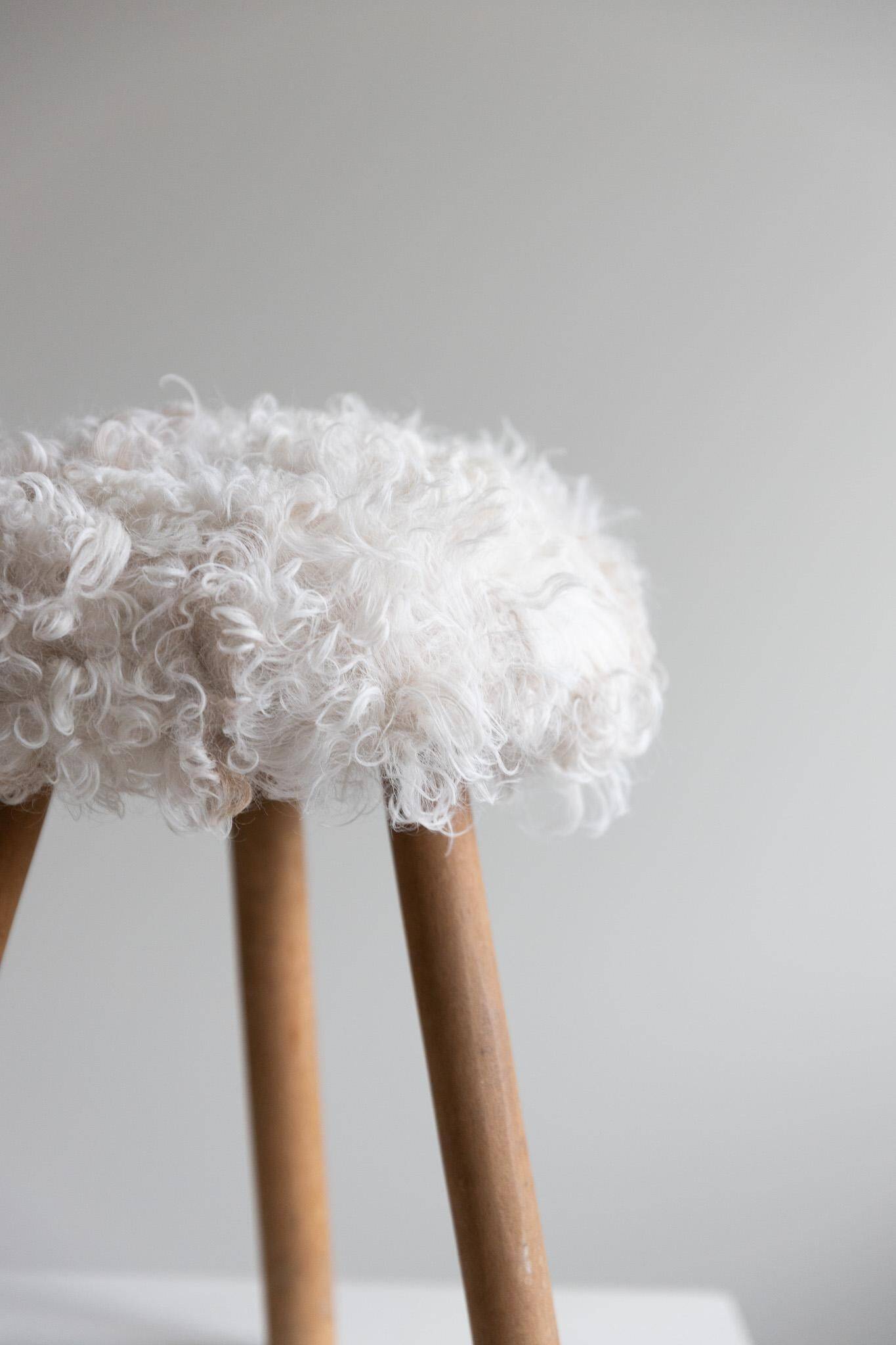 Danish mid-century tripod stool in beech, reupholstered in lambswool, 1960s.