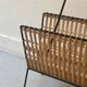 Black metal and rattan magazine rack by Raoul Guys, 1950.
