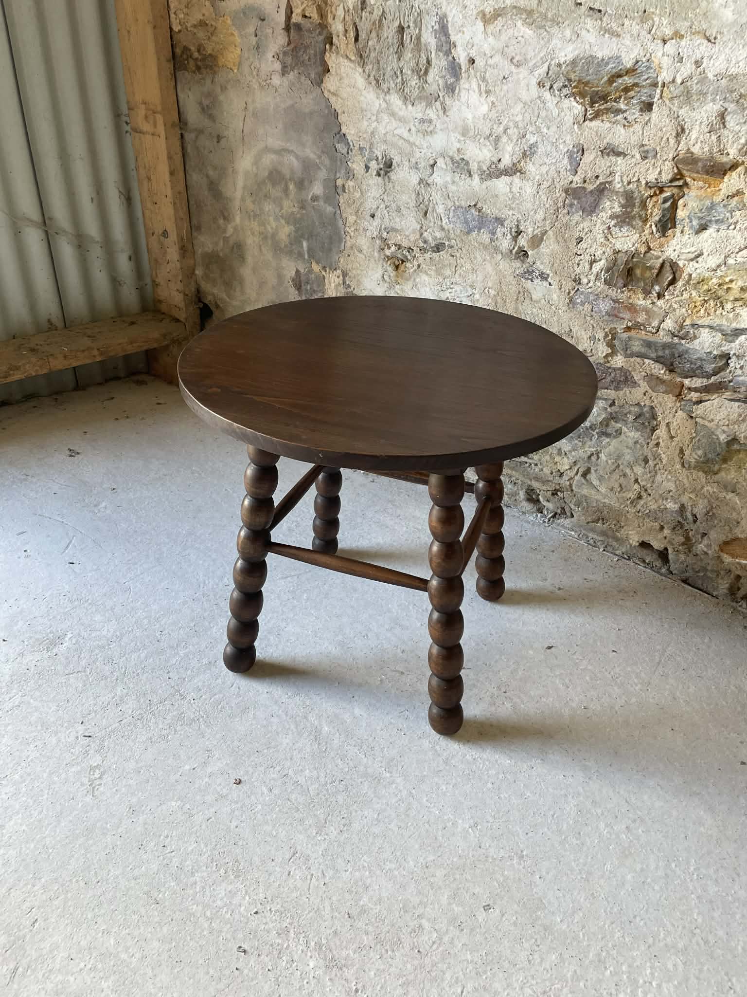 Round wooden coffee table with turned legs.