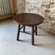 Round wooden coffee table with turned legs.