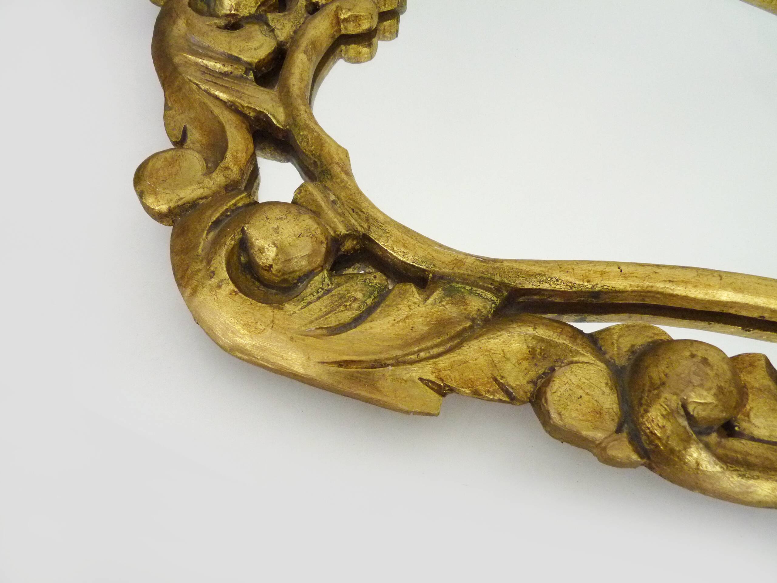 Old wall mirror in wood and gilded stucco with shell decoration, Louis XV style pediment mirror