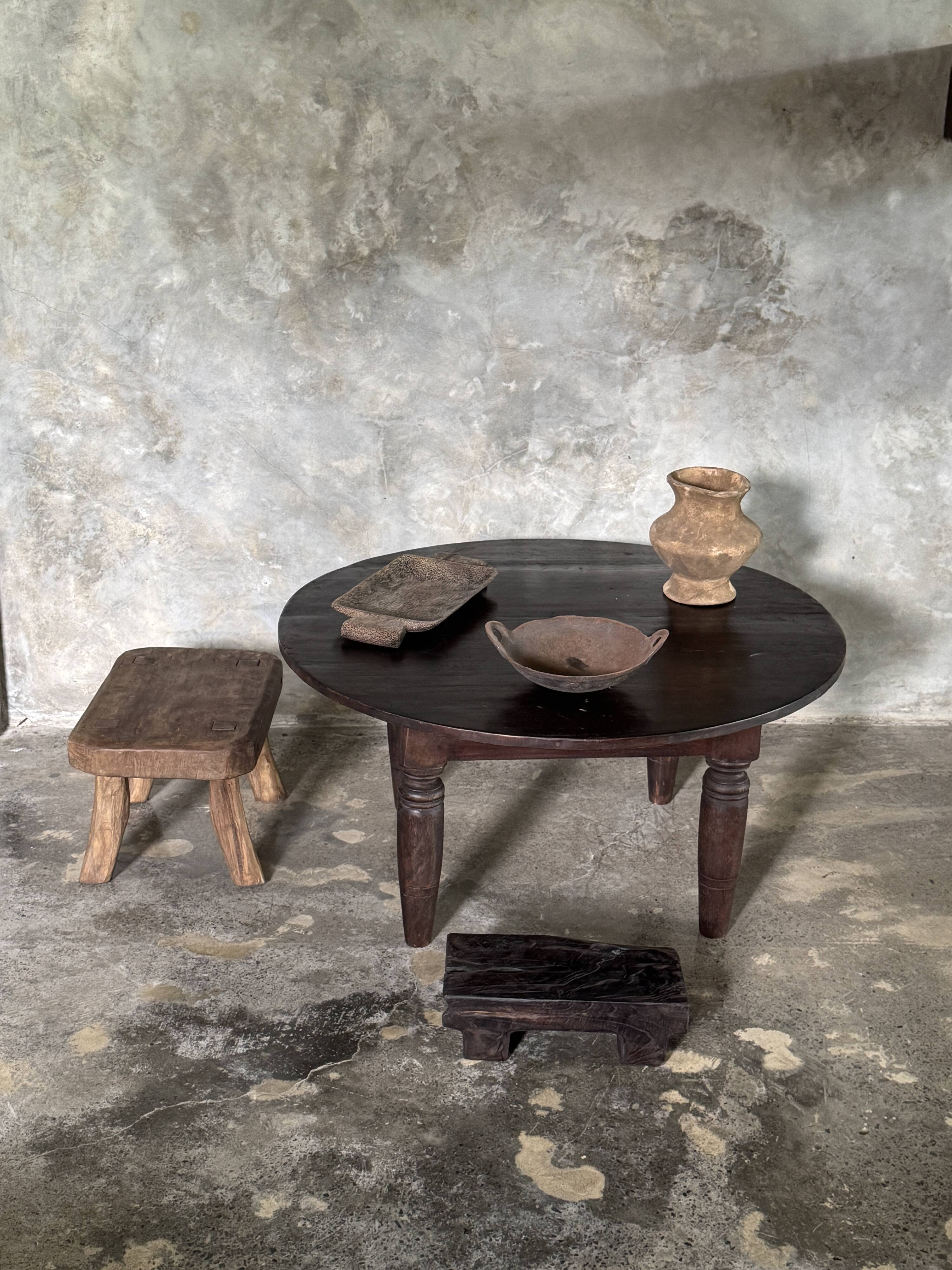 Antique round coffee table in Indonesian teak with turned legs.