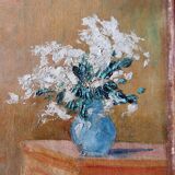 Huile sur toile - non signée - représente une femme assise à côté d'un vase de fleurs.