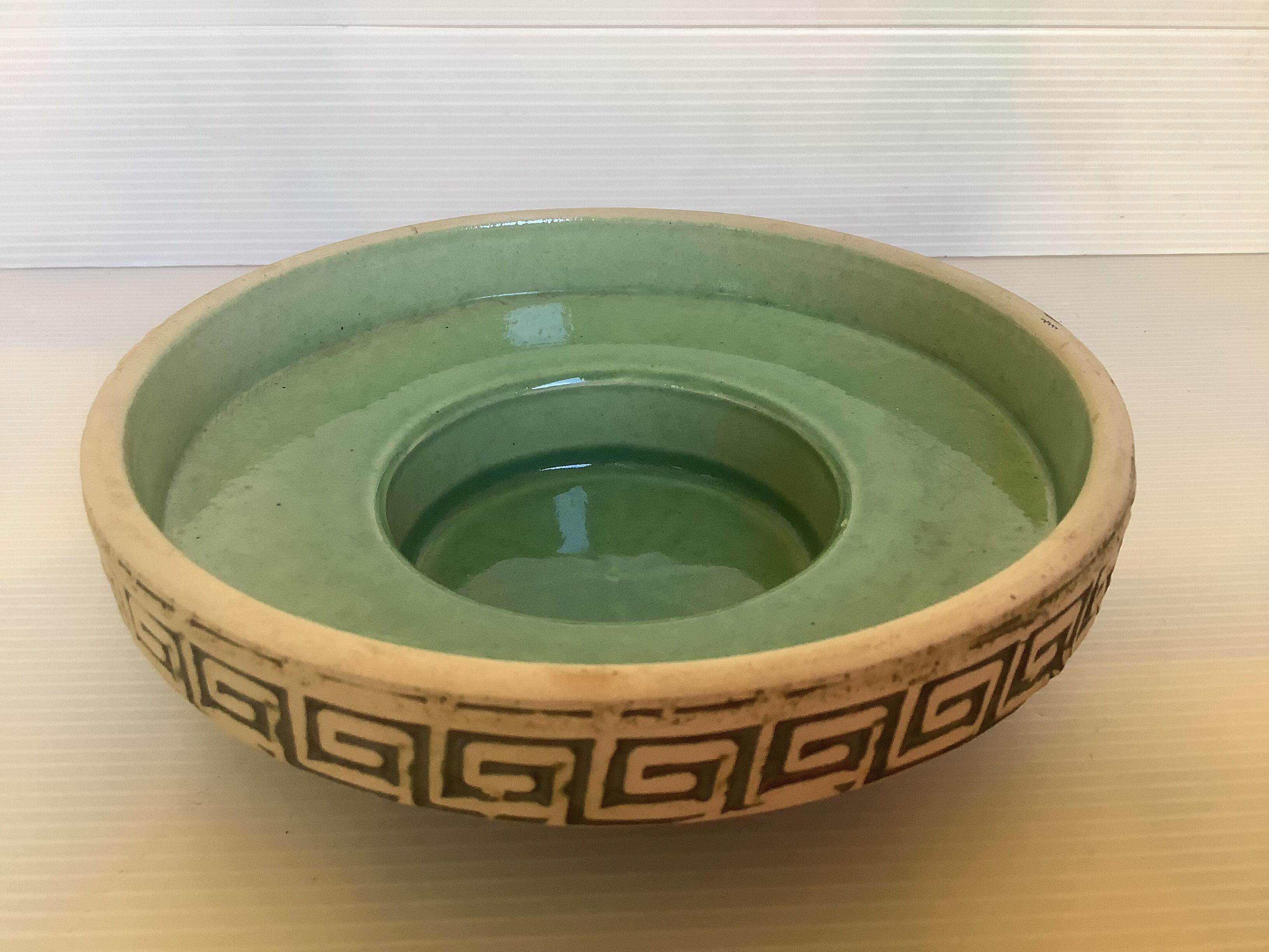 Green ceramic candle holder with a frieze