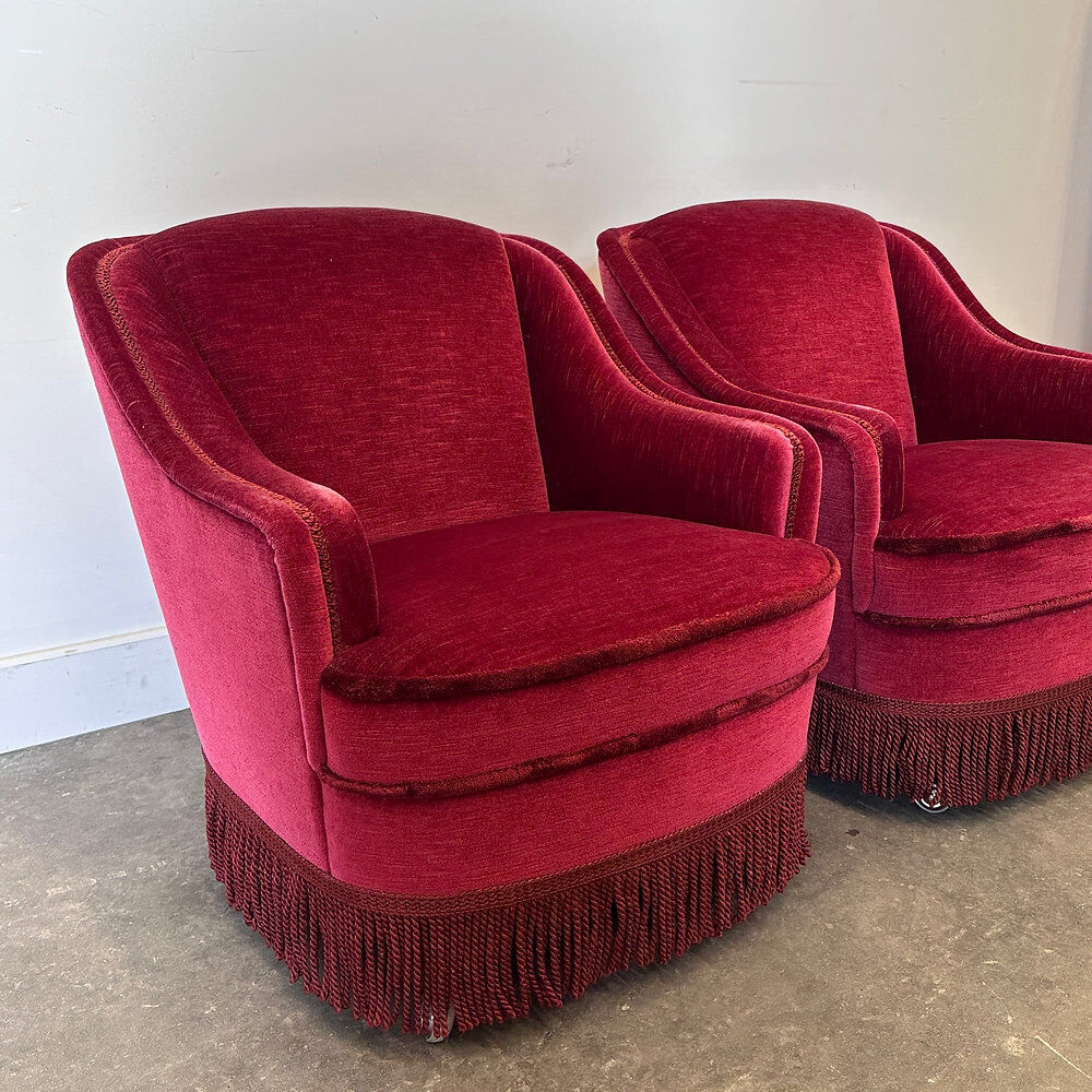 Paire de fauteuils de club vintage français en velours rouge profond avec jupe à franges, années 1960.