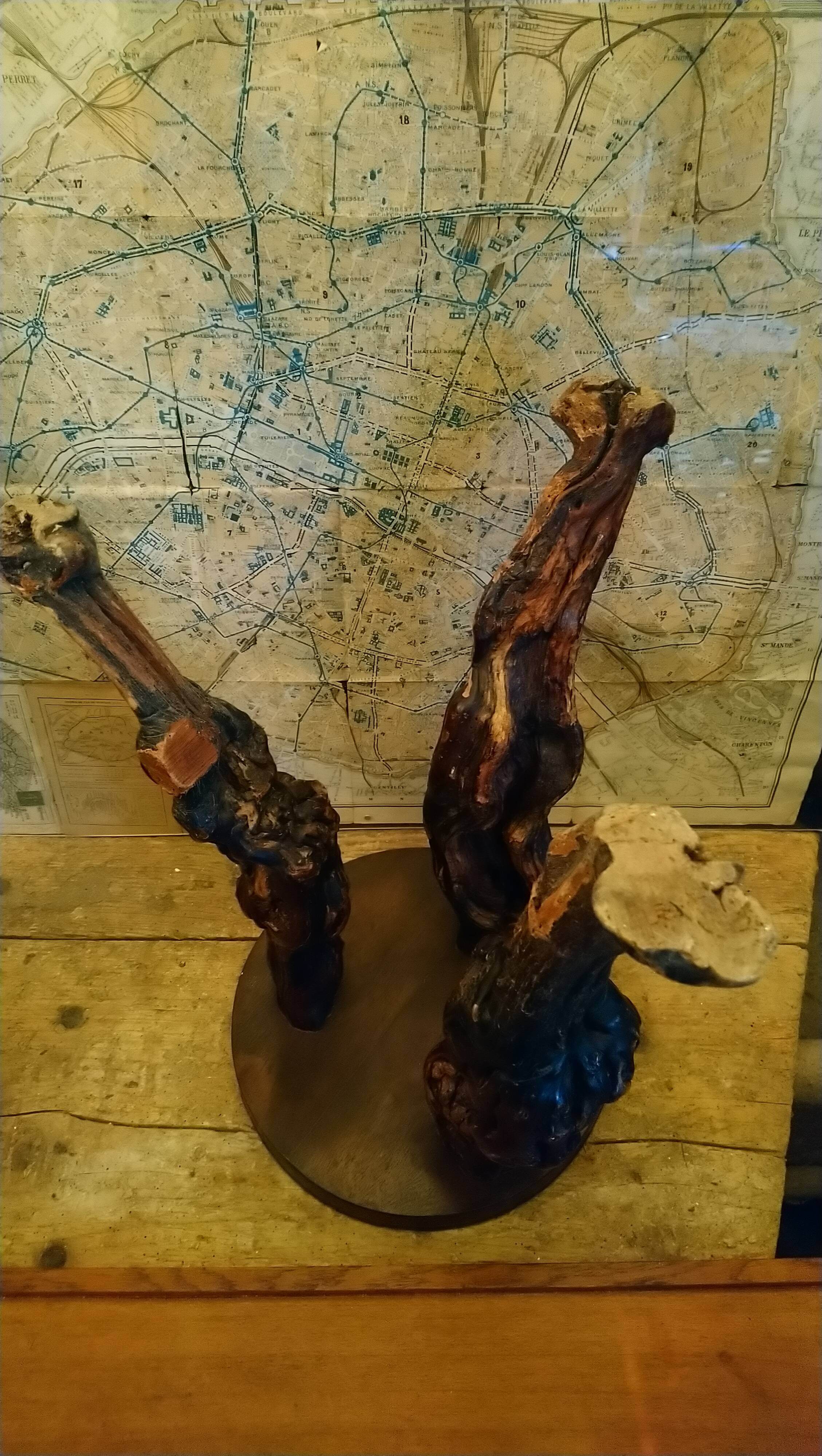 Brutalist tripod stool made from vine stumps.