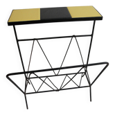 Black metal magazine rack and yellow and black tiled shelf.