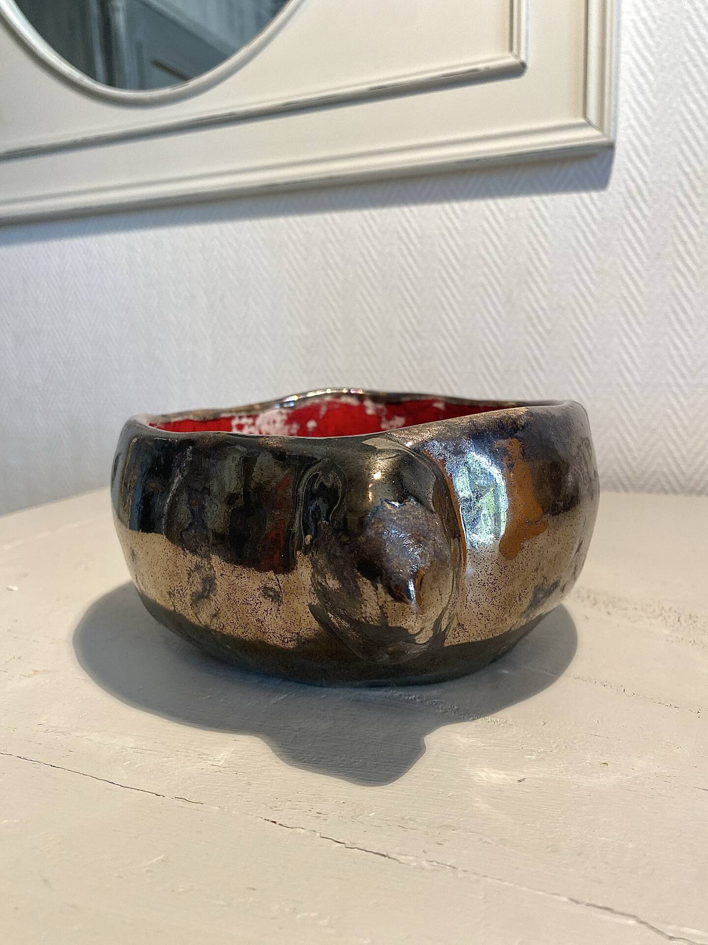 Deep red glazed and metallic ceramic catchall.
