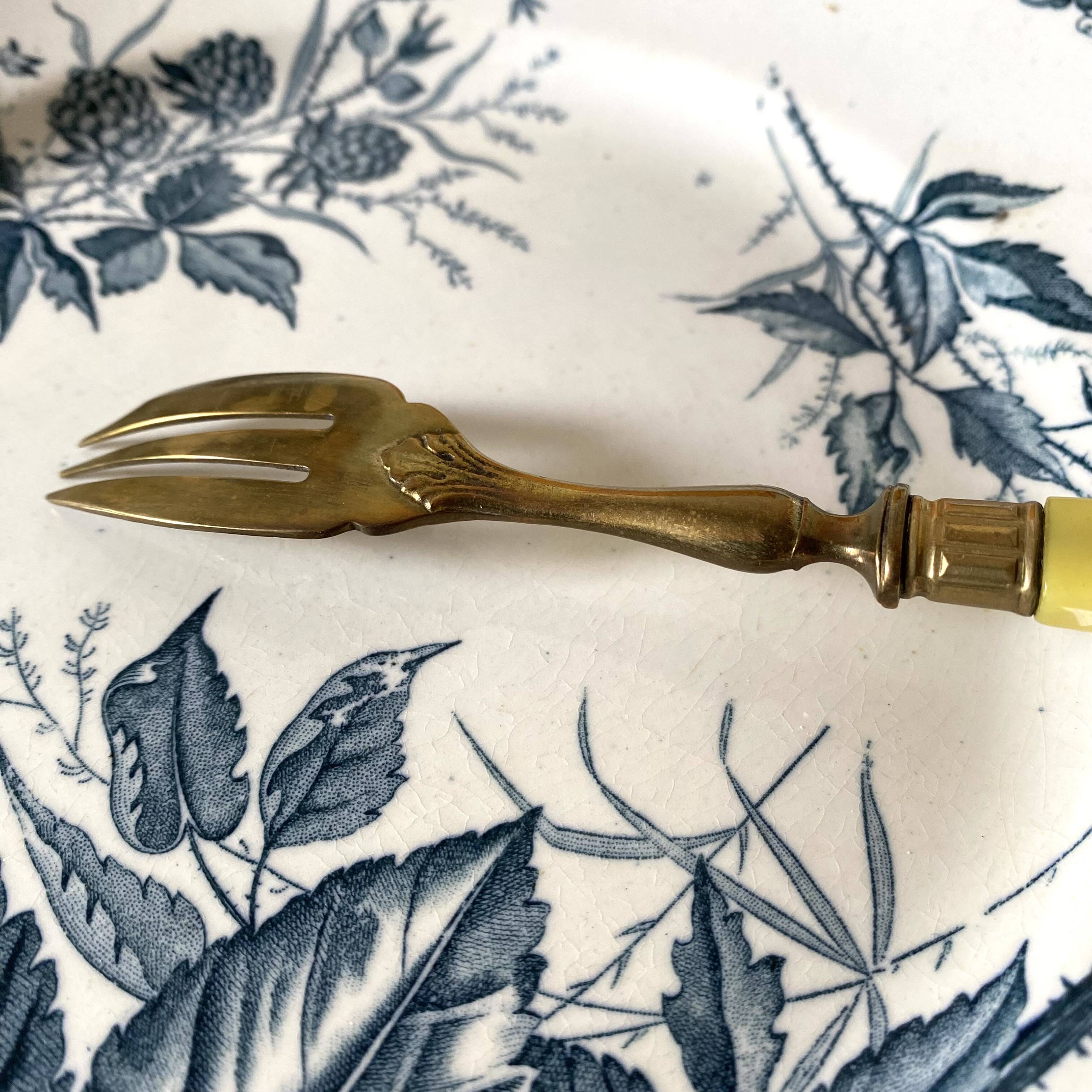 Antique dessert forks in brass and bakelite