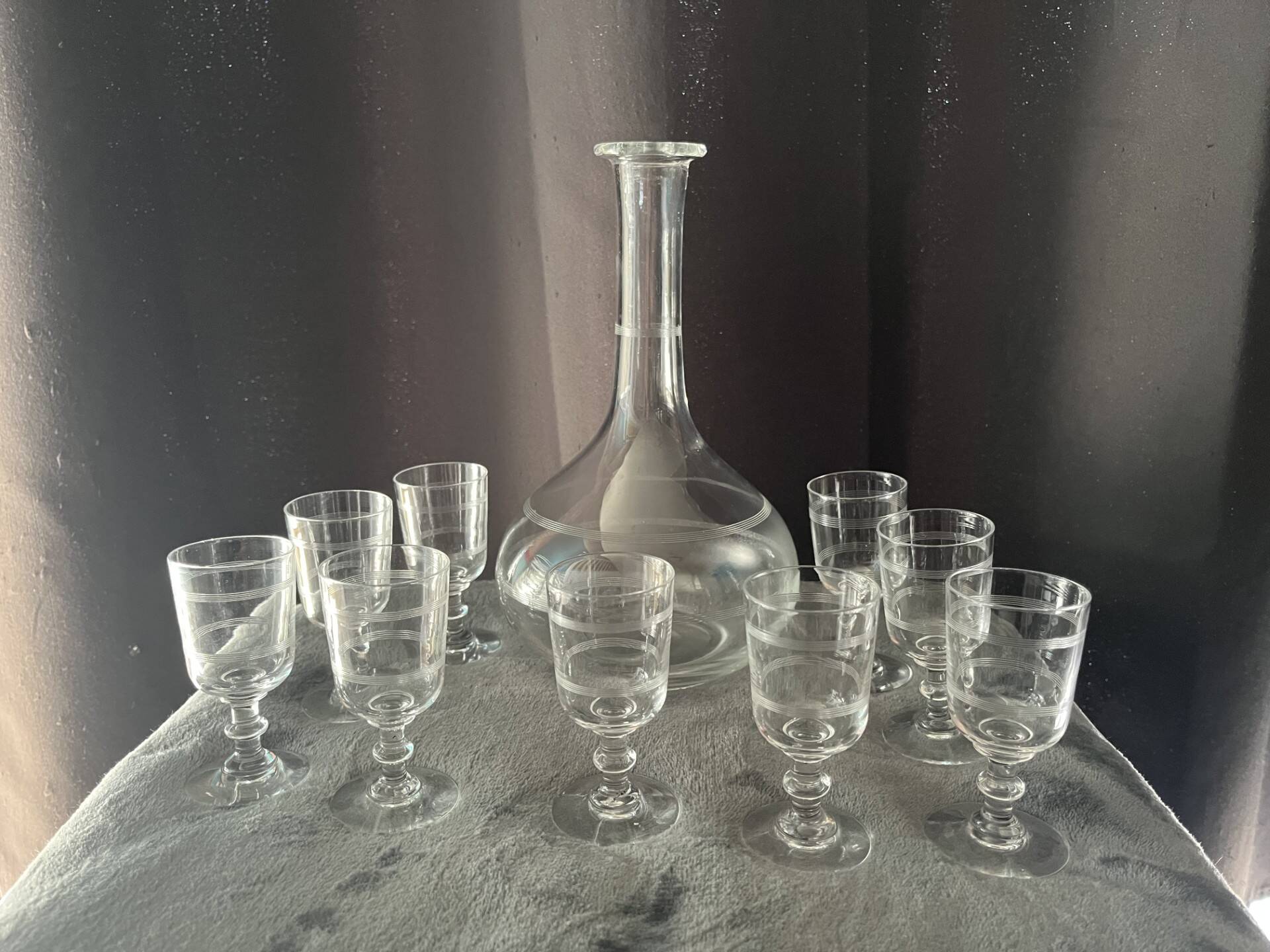 Service of an engraved art deco liqueur - captain's decanter and 9 matching glasses.