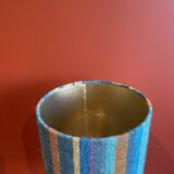 "Stoneware Bottle Lamp" with a multicoloured blue lampshade handwoven in India.