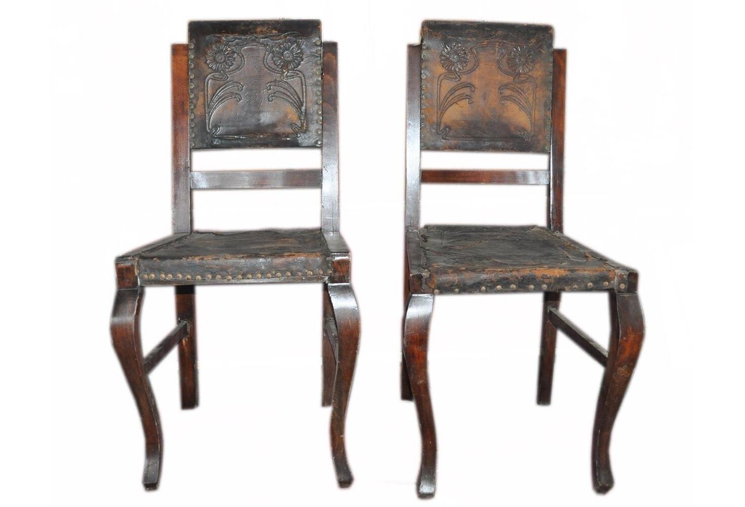 Pair of brown embossed leather chairs with brass studs and wooden frame, 1900s