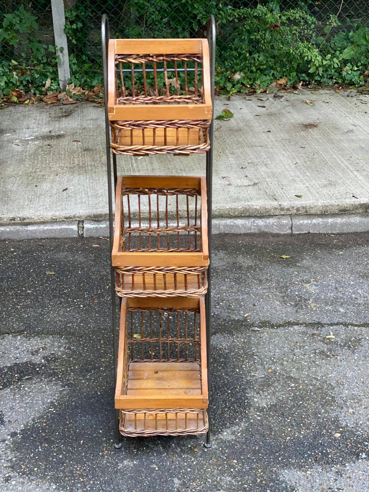 Woven rattan and steel display shelf in the shape of a staircase.