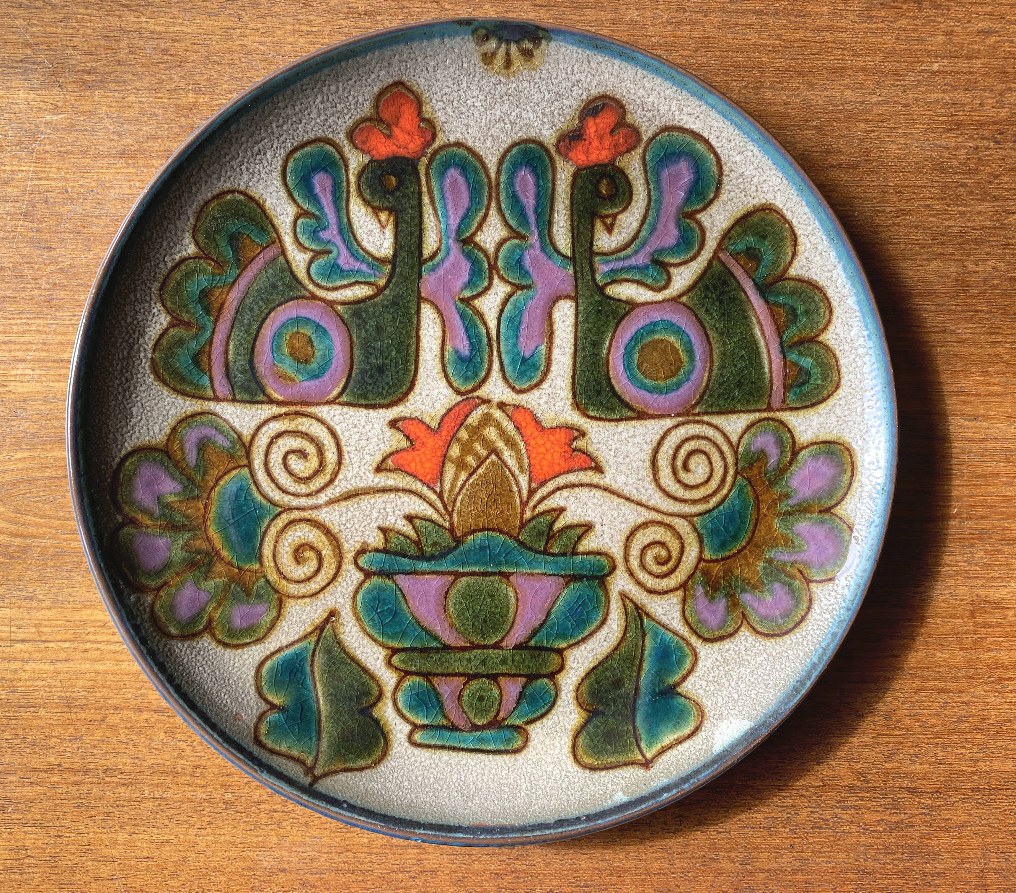 Vintage ceramic plate with peacock bird decoration.