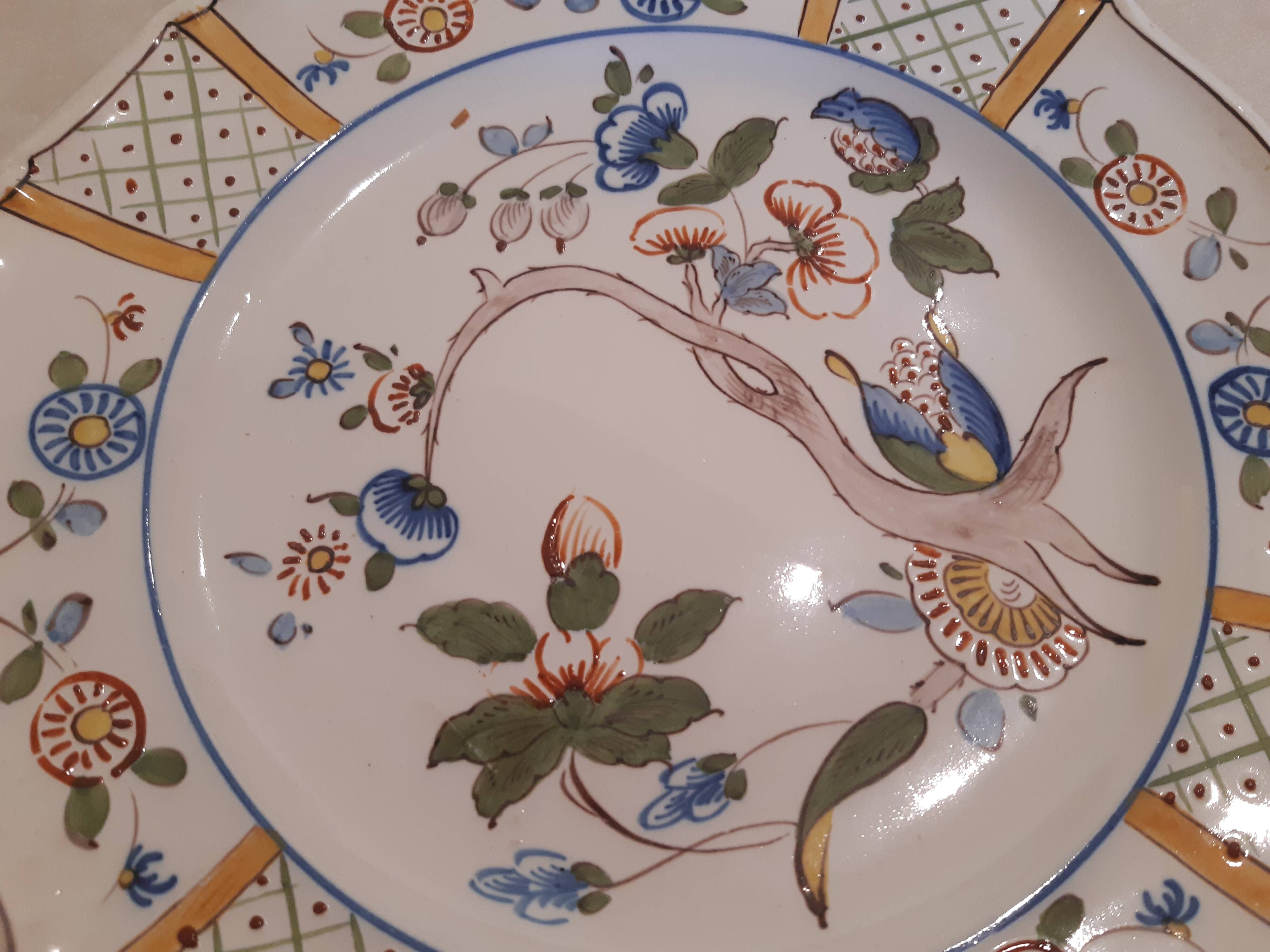 Flat plate in earthenware, hand-painted rural decoration partly in relief,