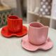 Set of ceramic artisan mugs with poppy red water lily design.