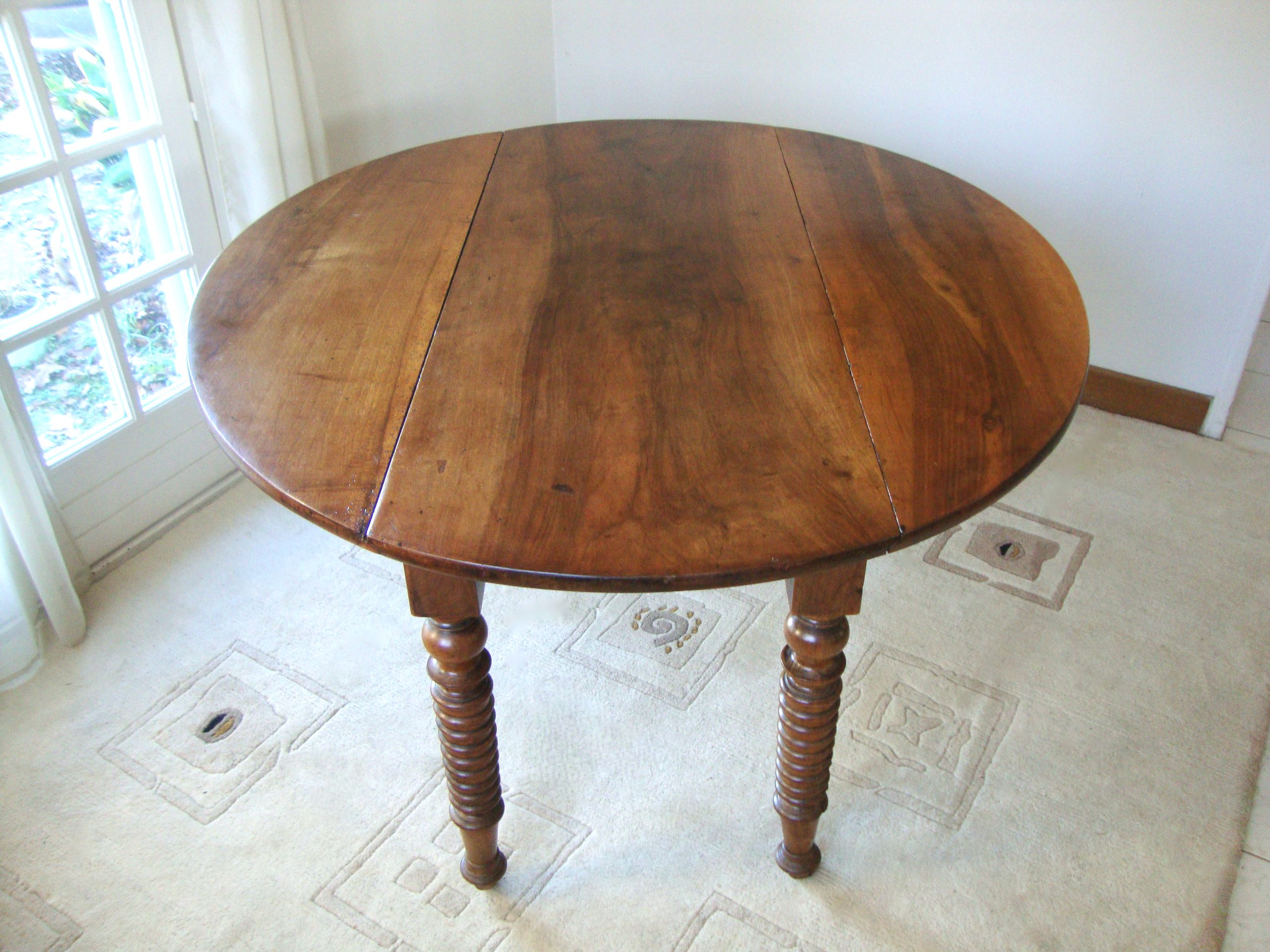 Mid-19th-century walnut round table with shutters, flaps