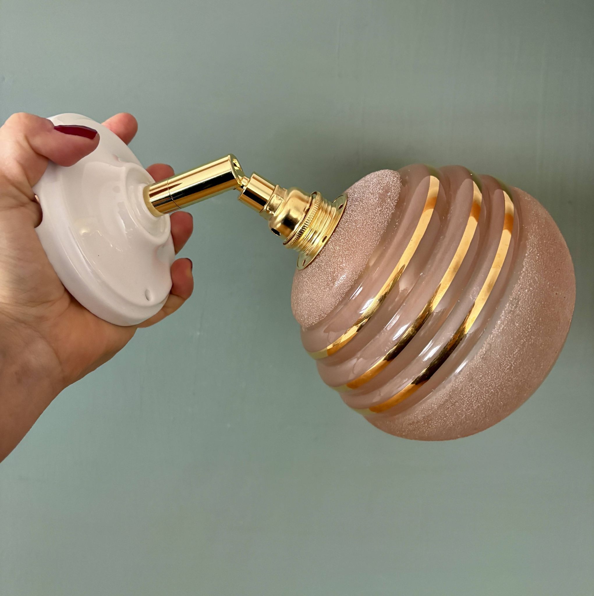 Vintage globe wall light in frosted pink and gold glass.