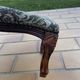 Antique wooden footstool with hand-carved details and floral upholstery –