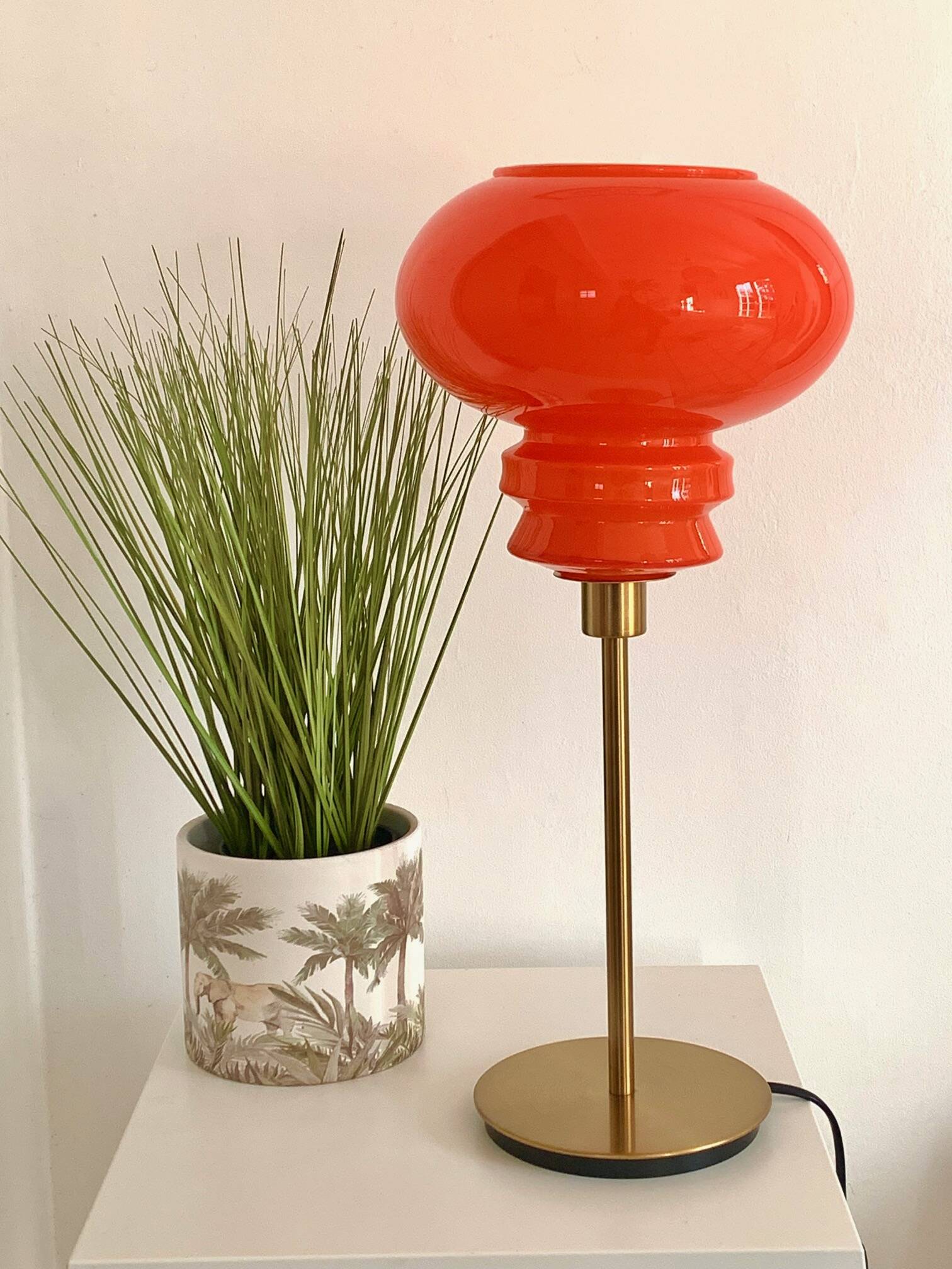 Lampe de table à poser réalisée avec un abat-jour vintage orange en verre et un pied doré