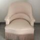 Pink armchair with patterns and fringes.