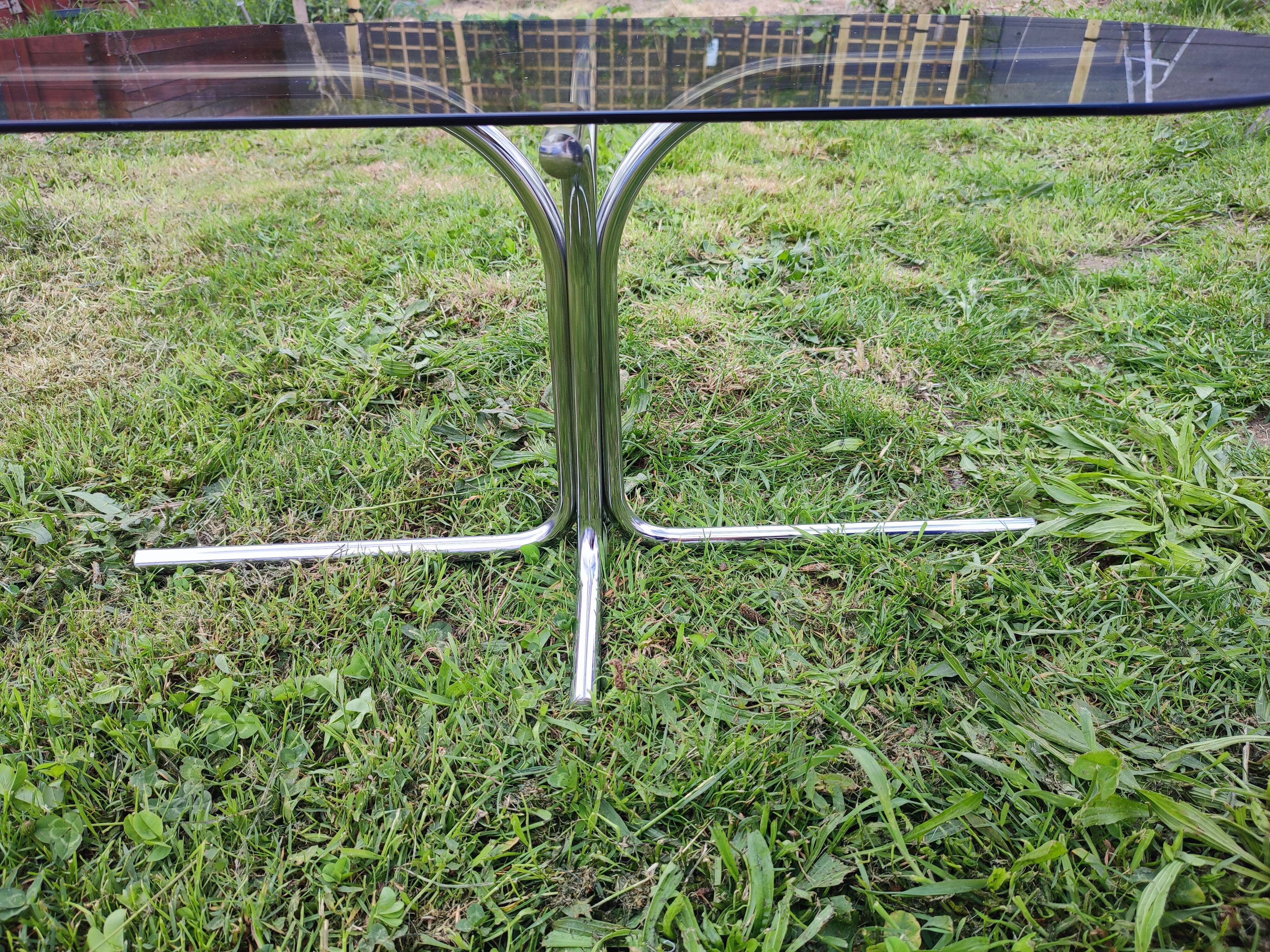Vintage coffee table with metal tube structure and glass top.
