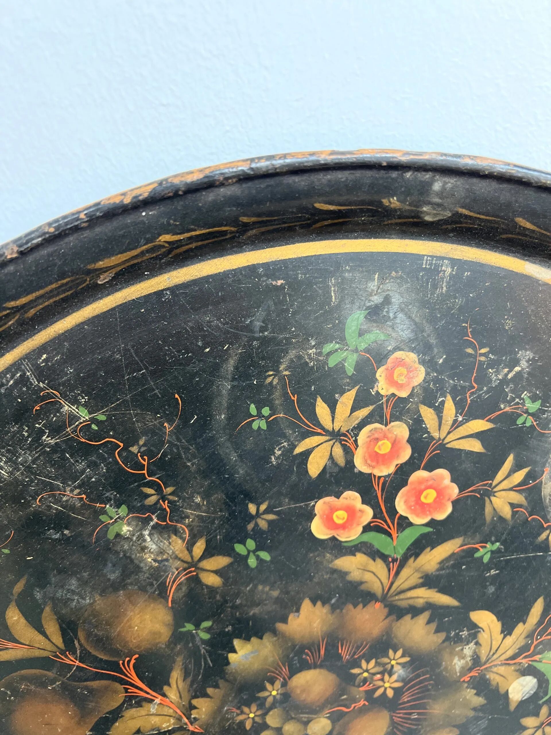 Round plateau, 19th century, painted black with fruit and grape decoration (49 cm)