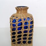 Blue bottle covered with wicker