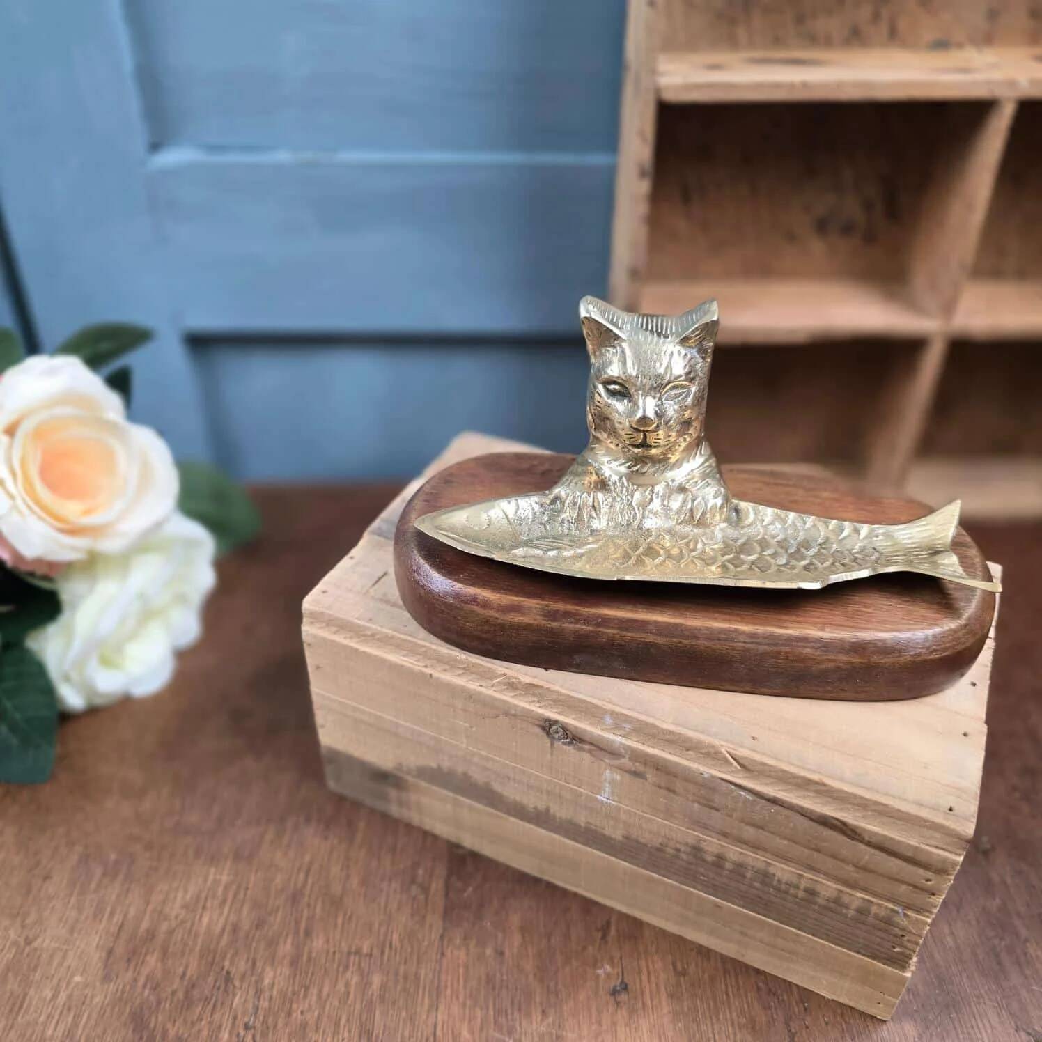 Vintage cat fish catchall in brass on a solid wood base.