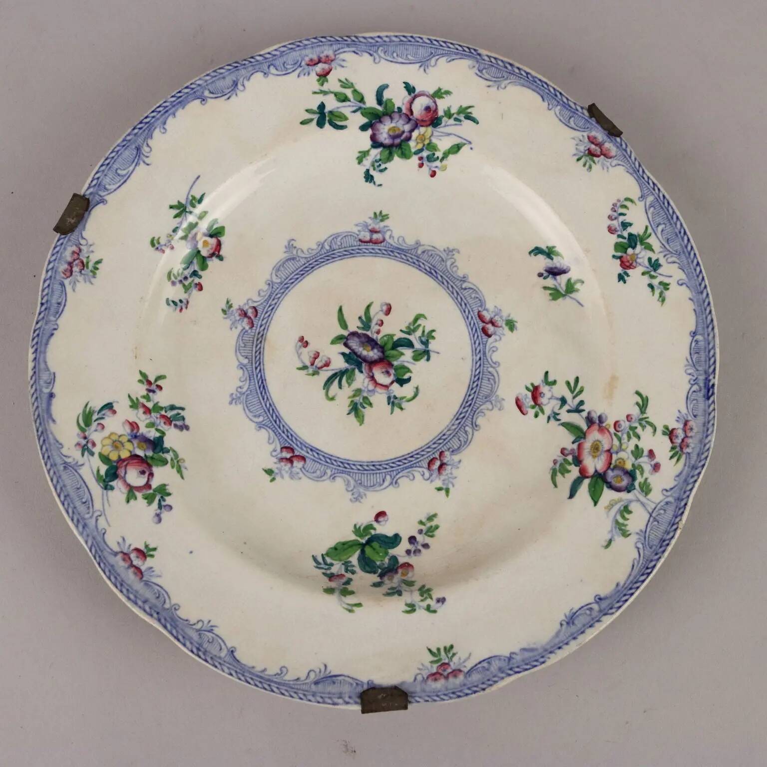 Antique earthenware plates with floral decoration from the 19th century.