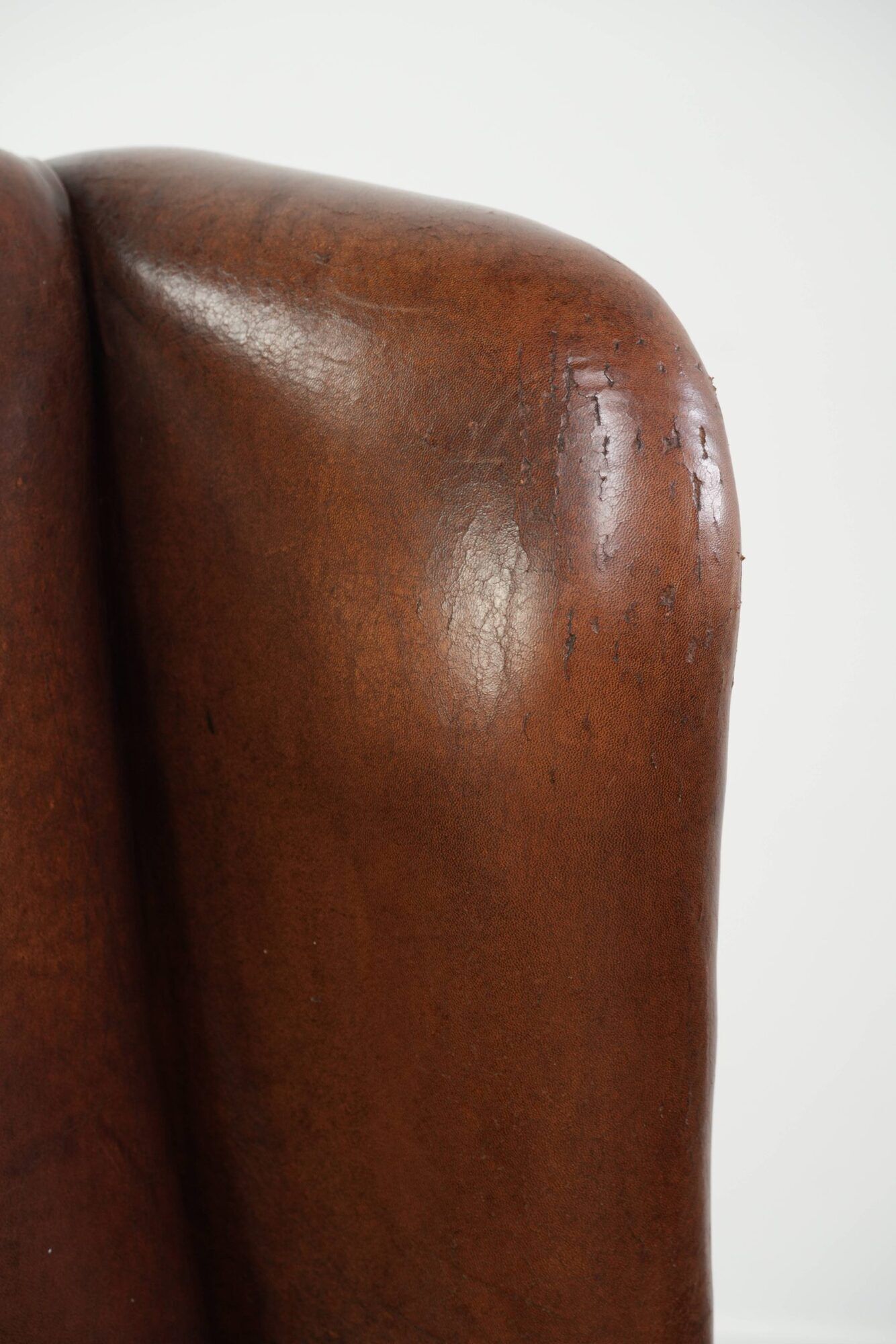 Sheepskin wingback armchair finished with black piping and a correct seat