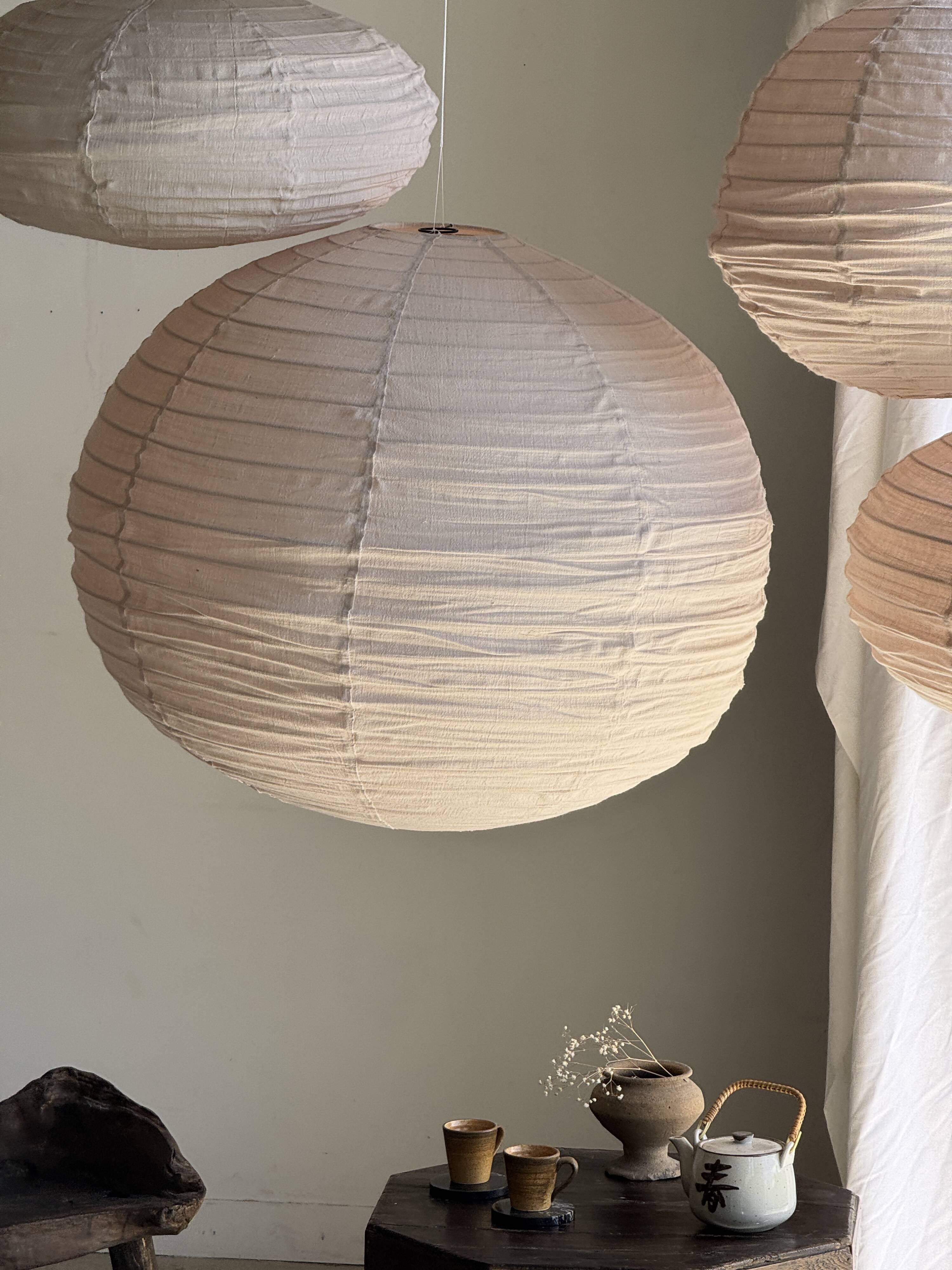 Average suspension in natural rattan and linen, Japanese-style, flattened oval in pink.