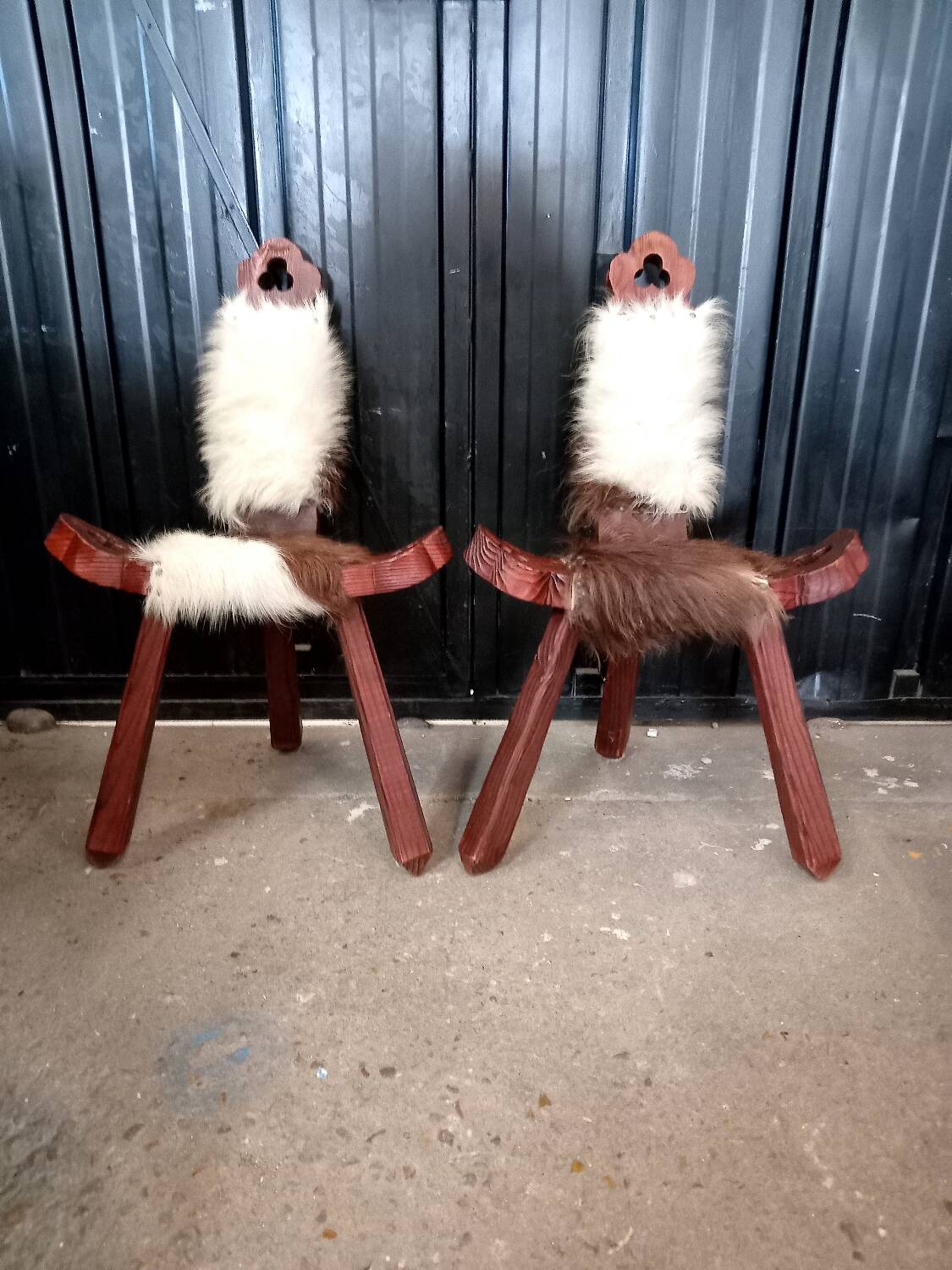 Pair of brutalist tripod chairs in wood and cowhide