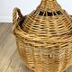 Old demijohn in her wicker basket