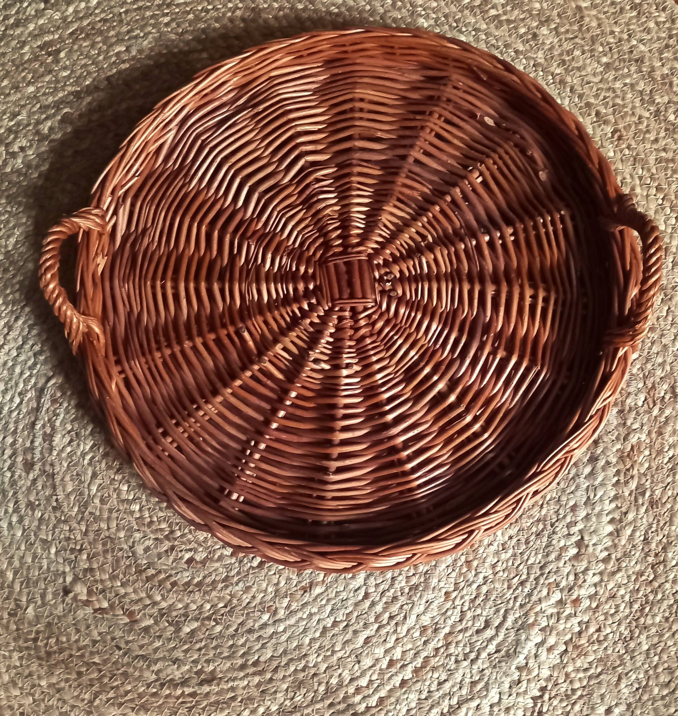 Large round dark wicker tray with two handles.