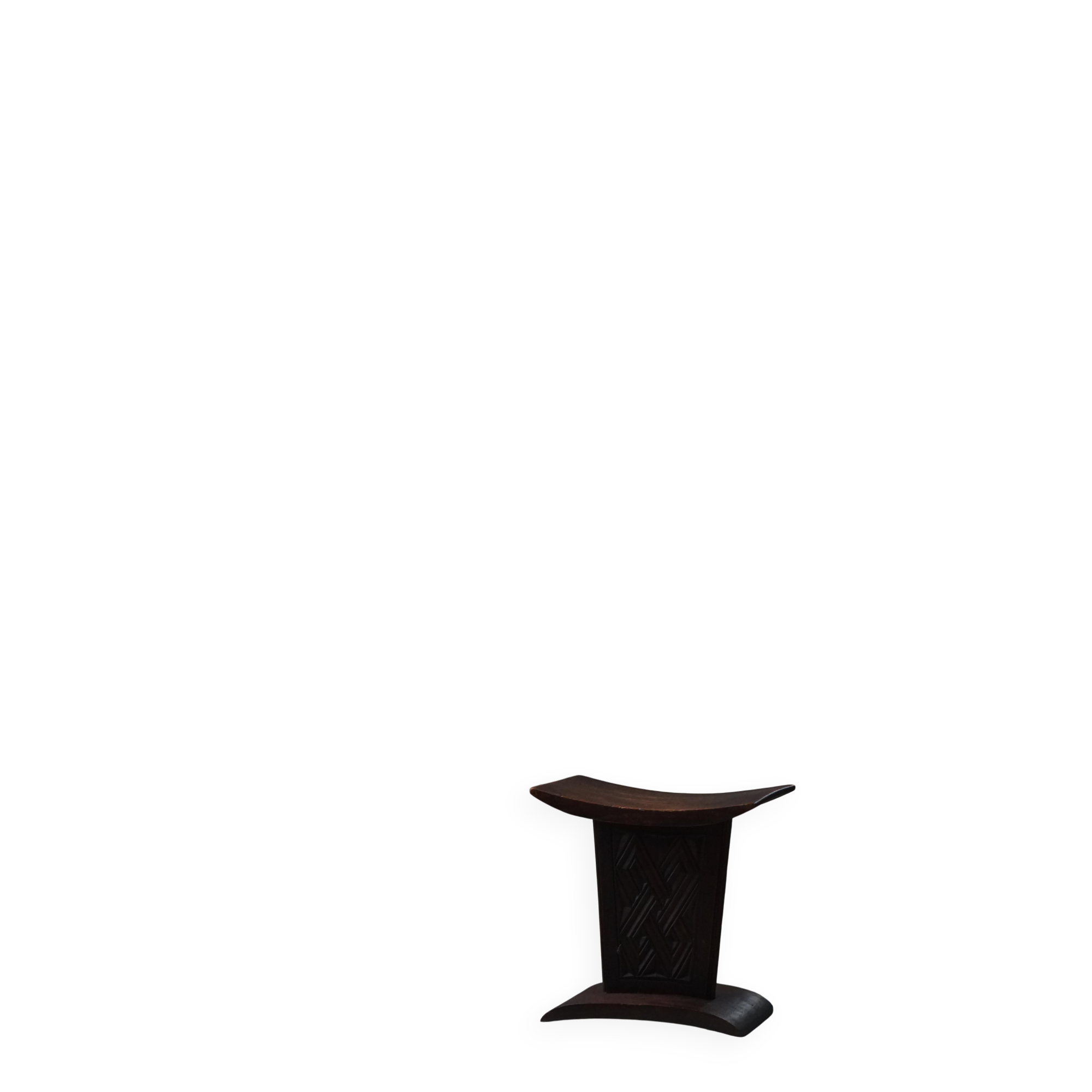 Sculptural African stool in hardwood, curved seat and architectural base, 1970s.