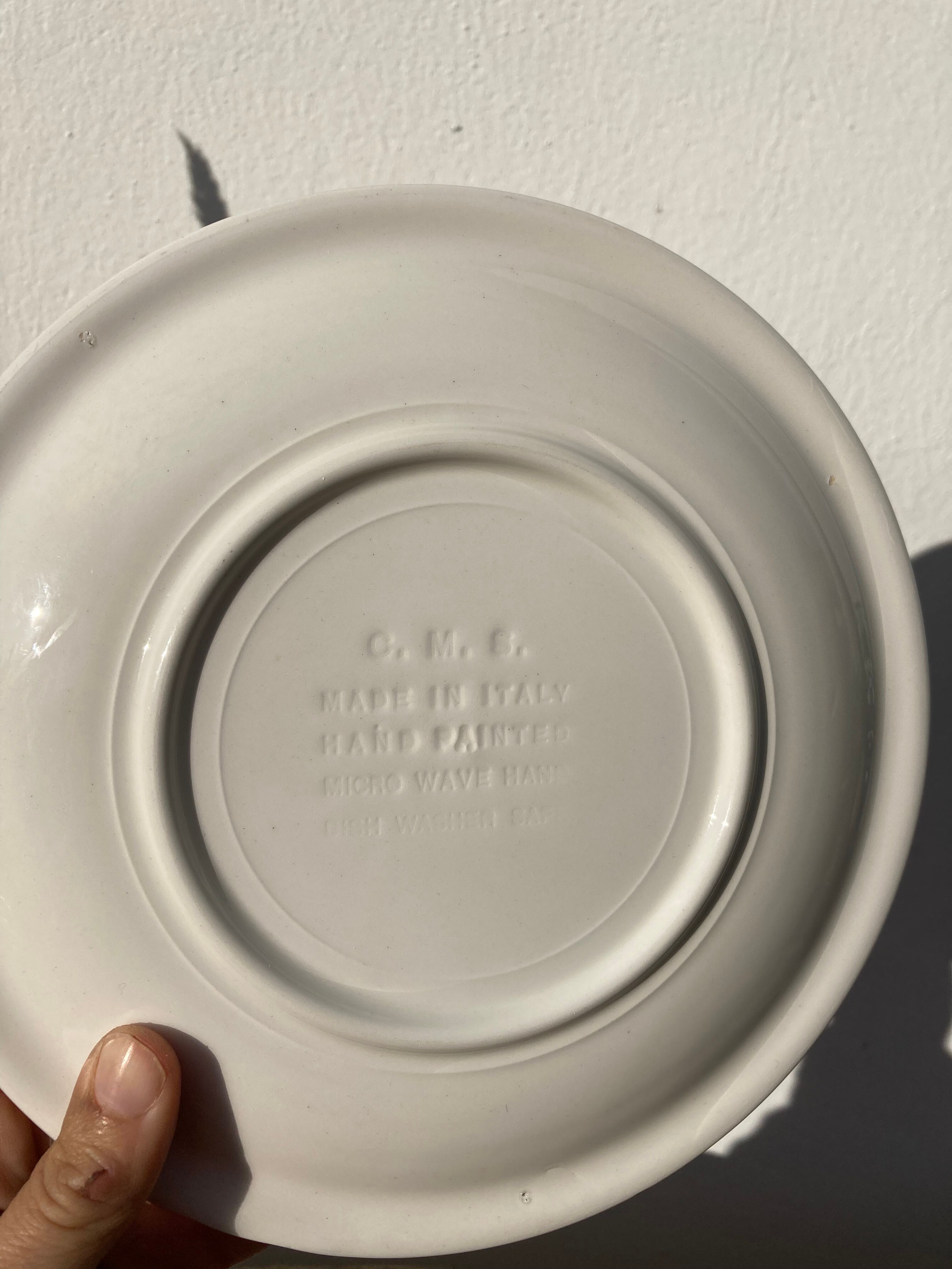 4 black speckled dessert plates on a vintage white background