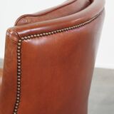 Cowhide armchair in good condition, finished with decorative nails