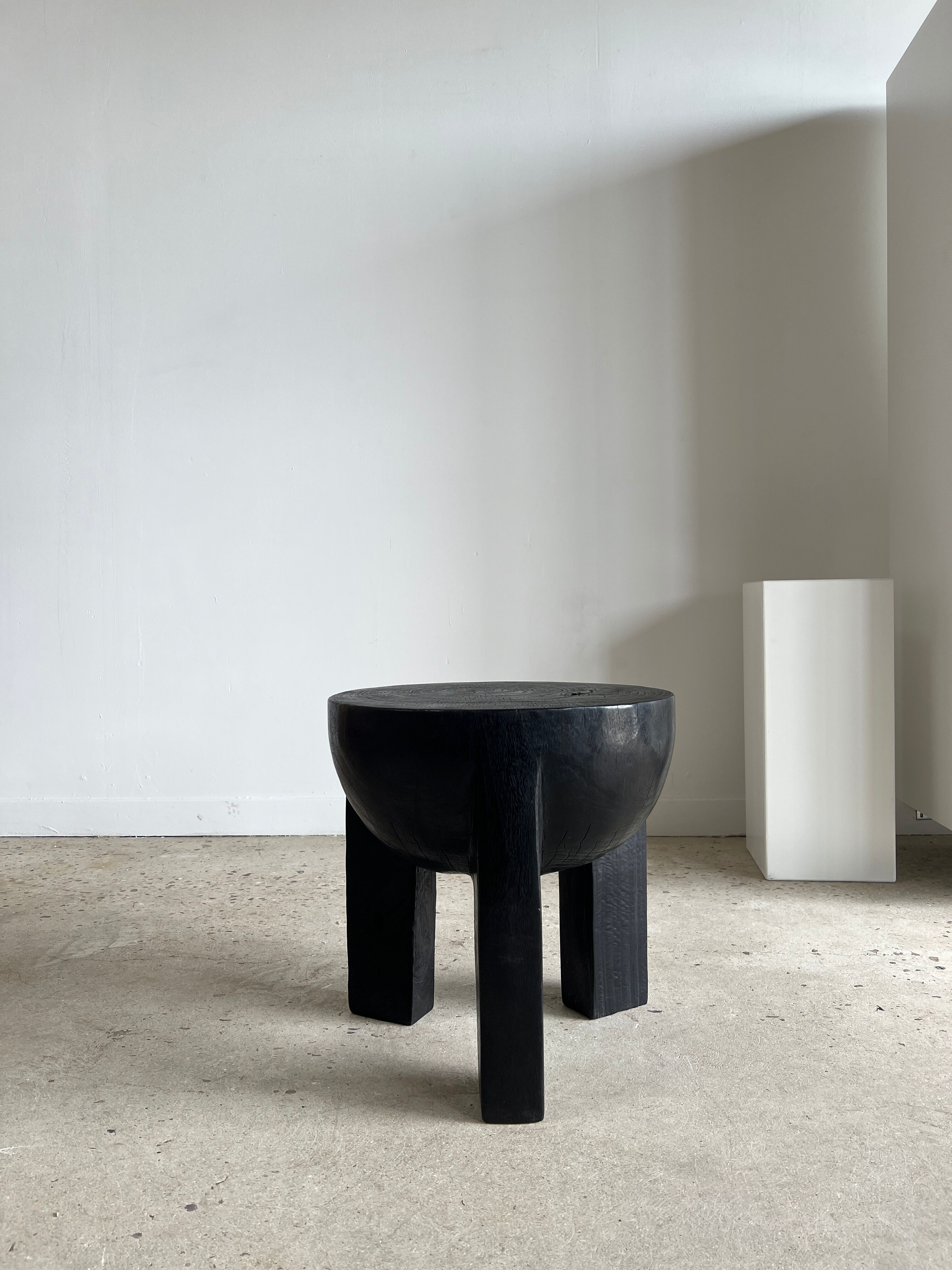 Black mango wood tripod side table with a semi-spherical top, height: 45 cm, diameter: 44 cm.