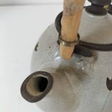 Beige stoneware teapot with stylized flowers and rattan handle