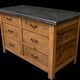 Old wooden workshop furniture with a stone top.