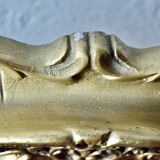 Old religious light frame in gilded stucco and curved glass